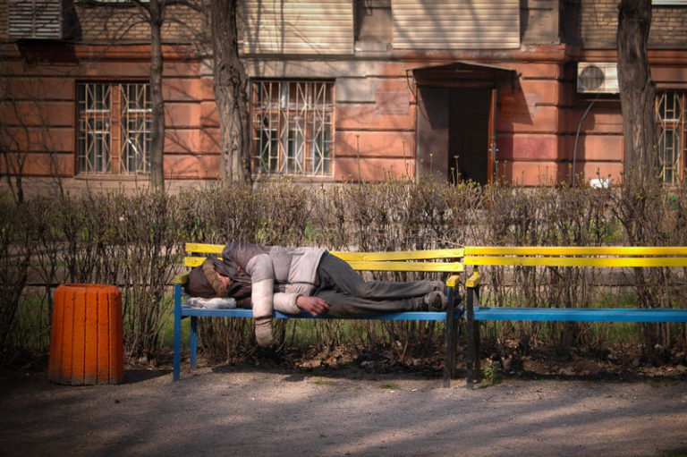 l-uomo-senza-tetto-dorme-su-un-banco-95260659